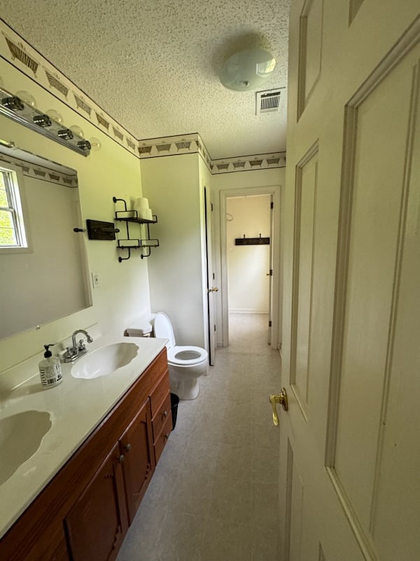 Double vanity sinks, toilet, linen closet.  Separate bathtub/ shower