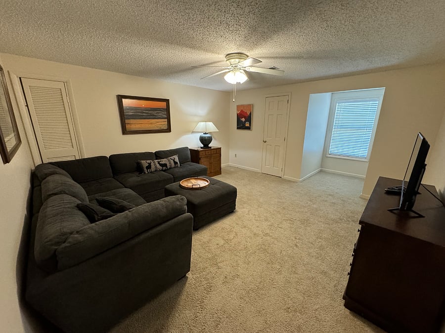 Spacious living room with comfortable sofa and TV