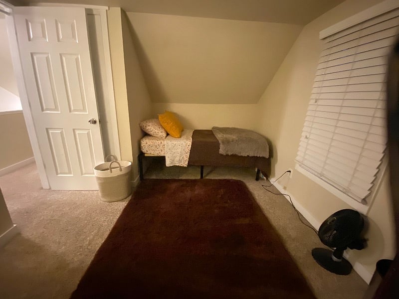 Bedroom #2 (upstairs on the left) has a woven laundry basket and an oscillating fan provided to keep the laundry off the floor and air circulating and cool.