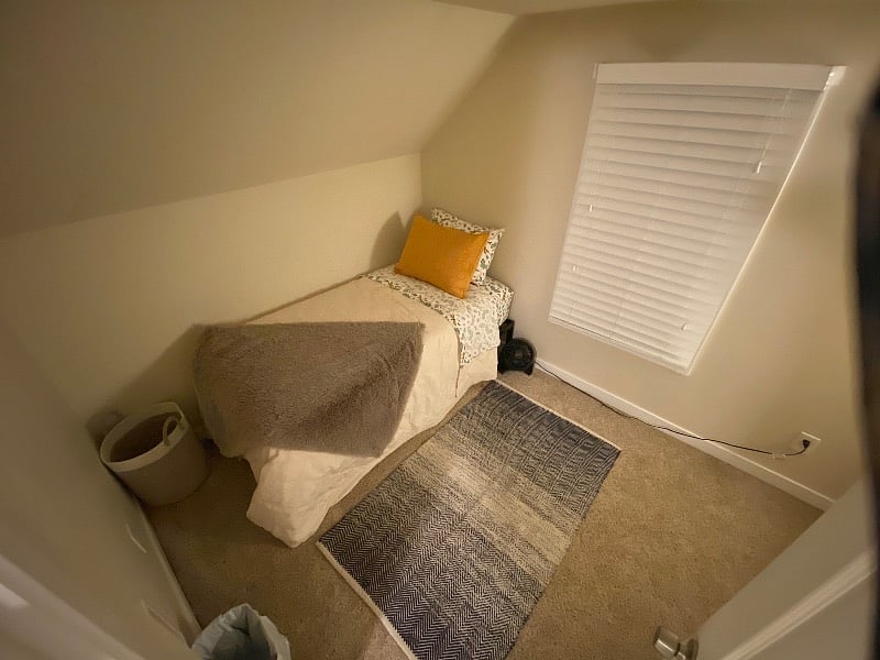 Bedroom #1 view of new twin bed with new steal frame, bedding, new cozy blankets, pillows, rug and woven laundry bag and small fan.