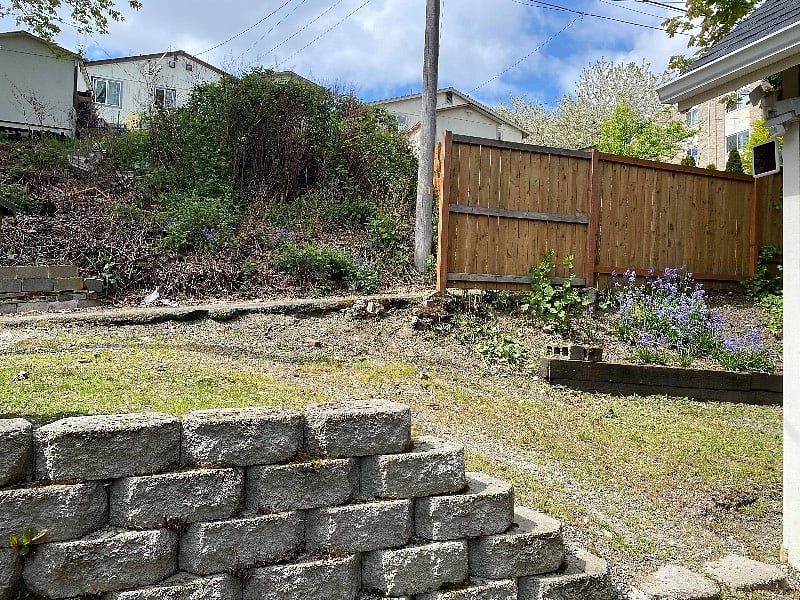 View of the back of the house and the grade of slope, showing the alley way.
