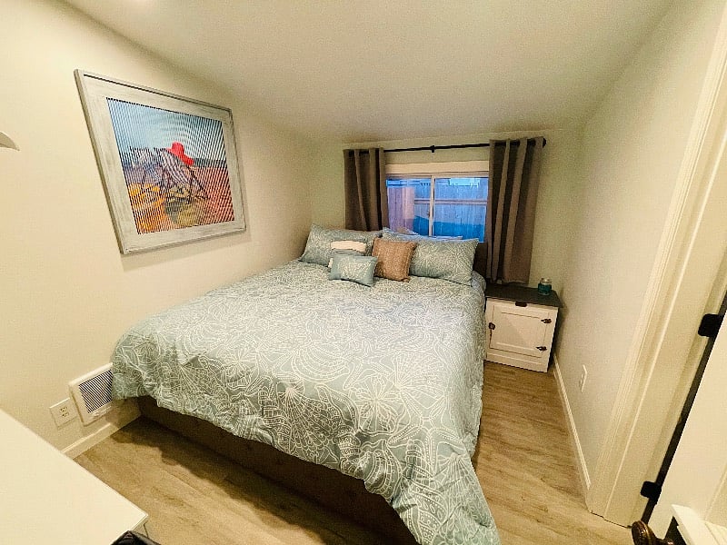 Master bedroom with king size bed and blackout curtains.