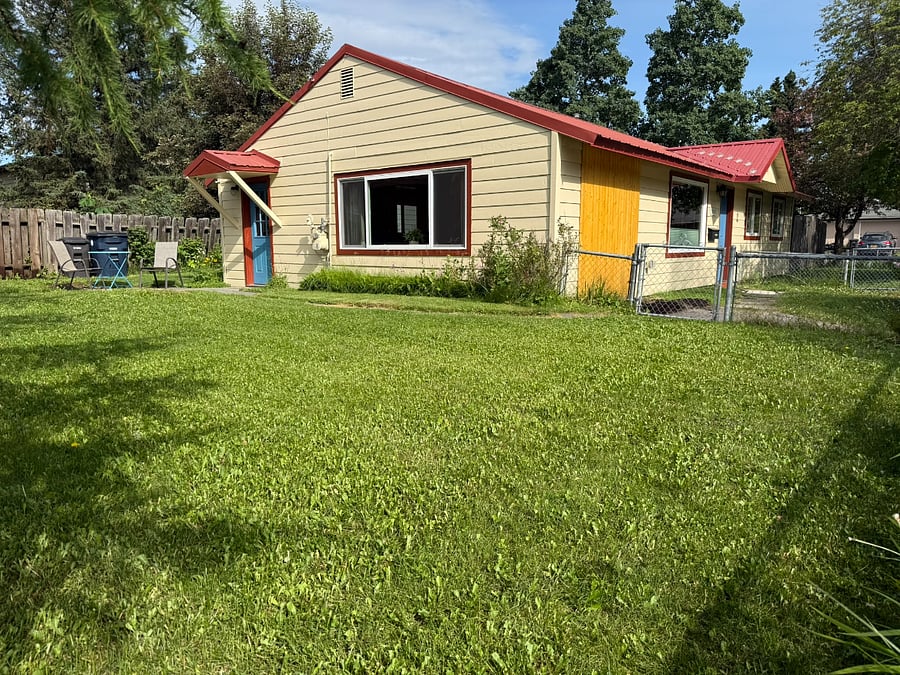 Side south facing yard and chairs and table to sit outside.