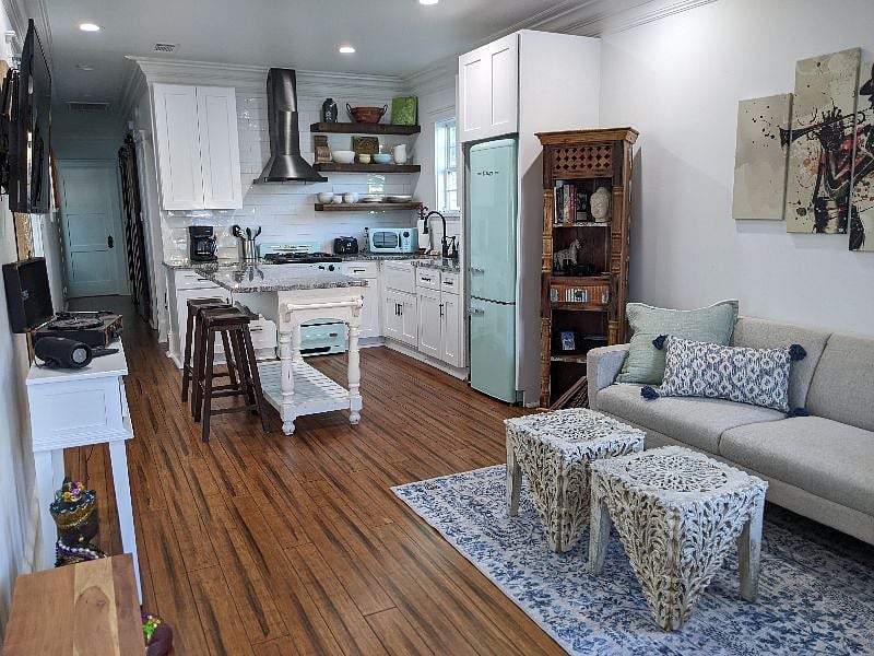 Living room and eat-in kitchen. Stools at the island are a perfect place to enjoy a meal.