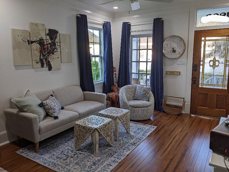 Cozy living room includes movable coffee tables that provide additional seating if needed. Corner chair swivels for a great view out the windows.