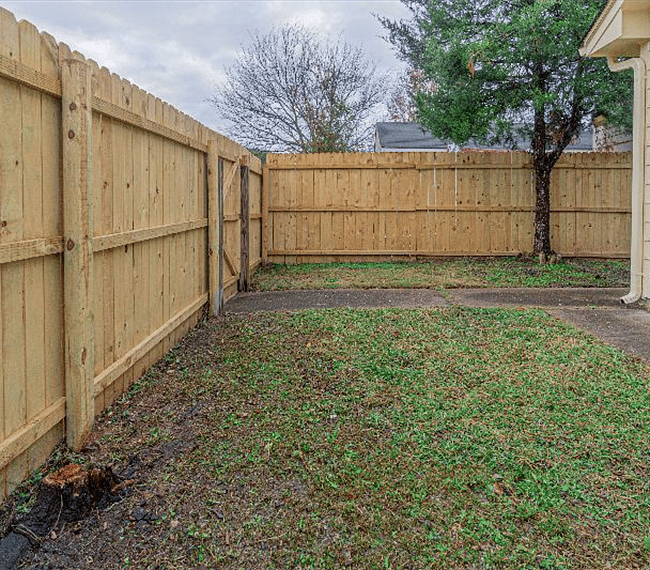 Large grassy patio with fence
