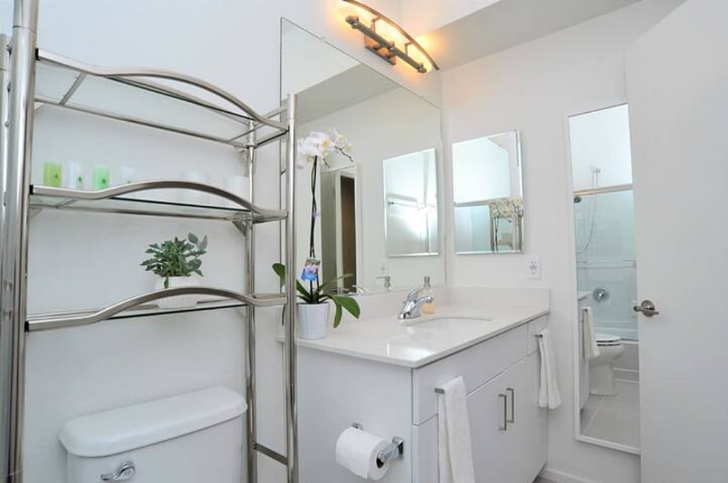 Large shared bathroom with quartz counter top.