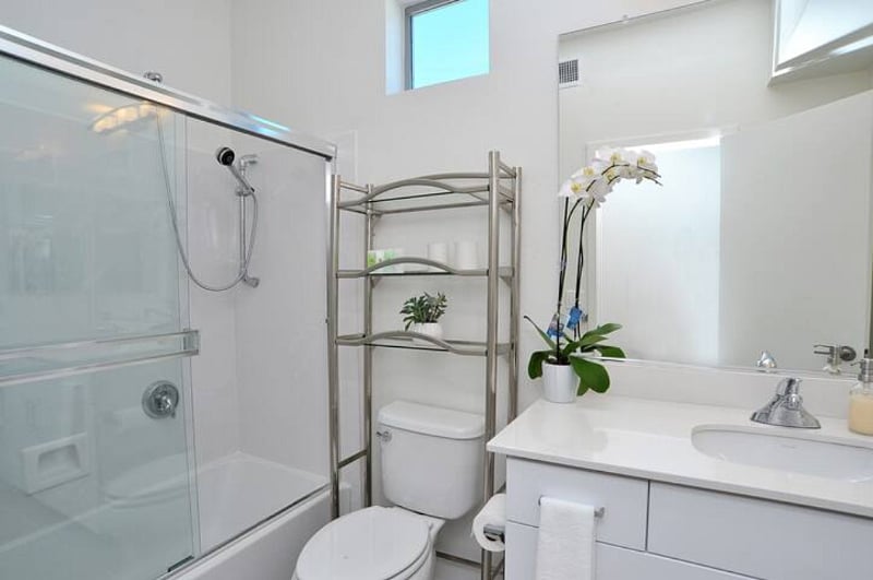 Shared bathroom with bathtub, two shower heads, and a commode with bidet.