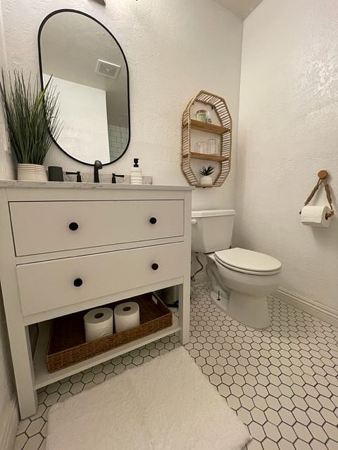 The master beddroom features a newly remodeled private bathroom with a beautiful marbeled vanity, ample storage space, and a honeycomb tile floor.