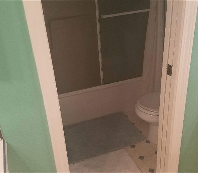 Toilet and shower are behind a sliding door in bathroom.