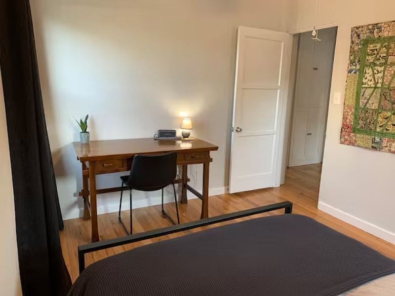 Front bedroom, large desk and queen bed.  Closet with drawers and hangers.