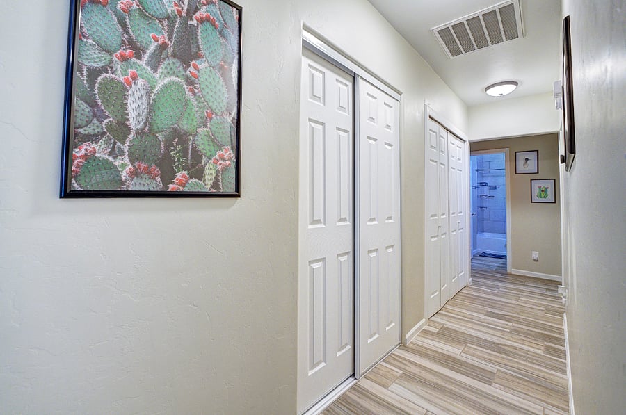 Looking down the hallway, bathroom at the end between both rooms.