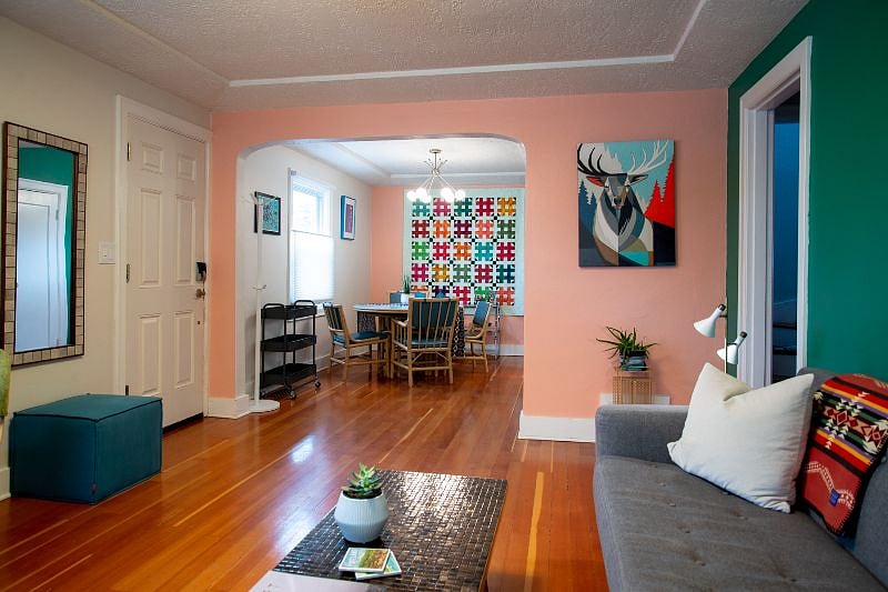 Dining area features colorful art and hand stitched quilt #colorful