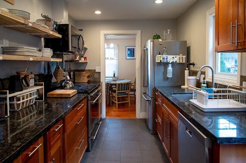 Generously appointed galley kitchen features newer appliances, open shelving, and brand new chefs knives and tools.