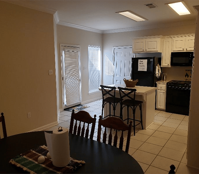 View of kitchen from dining area with doors to patio and garage.