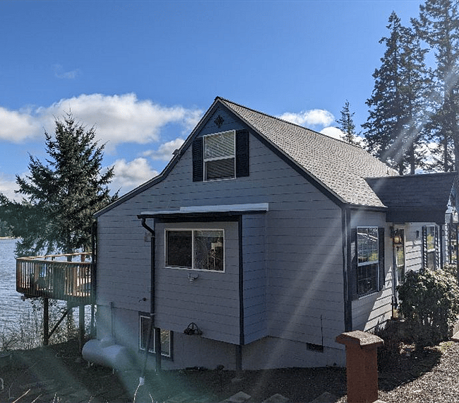 View of left side of home with lower alcove and upstairs bedroom