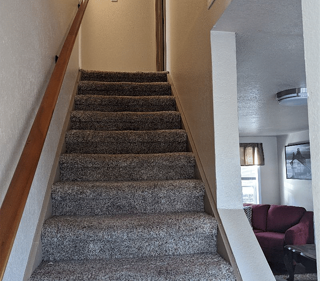 Stairs to upper secondary bedroom and office.