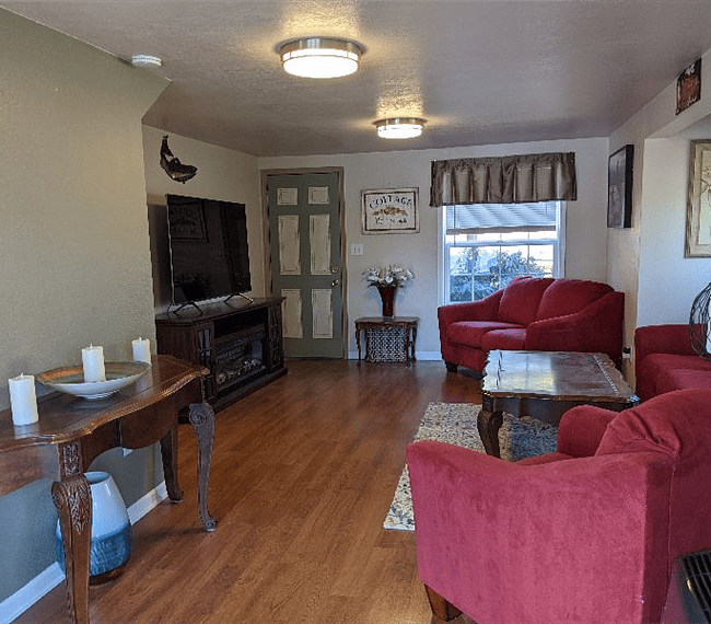 Living room with HD TV, couch, loveseat and chair.