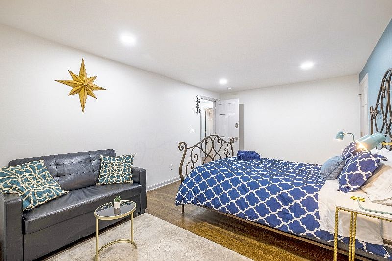 Spacious upstairs bedroom with a queen-sized iron bed  elegant design meets everyday comfort.