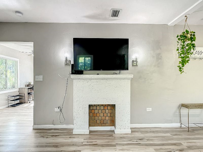 A closer look of the TV set up, conveniently set up right above the decorative fireplace.