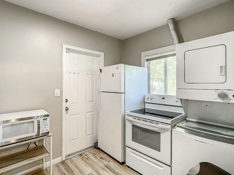 The other half of the kitchen includes the stove, fridge, washer and dryer.