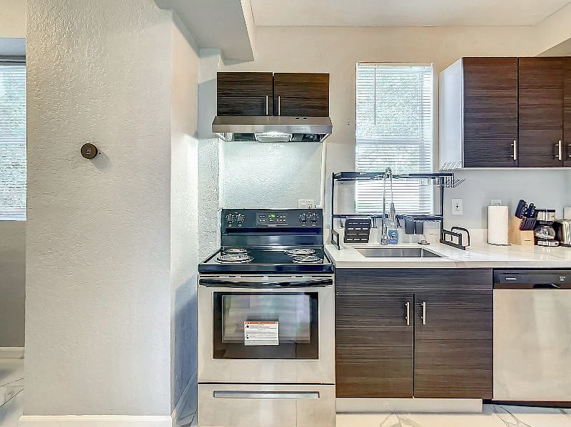 Enjoy a vented stove, a modern over-the-sink dishrack, a deep sink, dish washer, and plenty of cabinet space -- not all cabinets are pictured here!