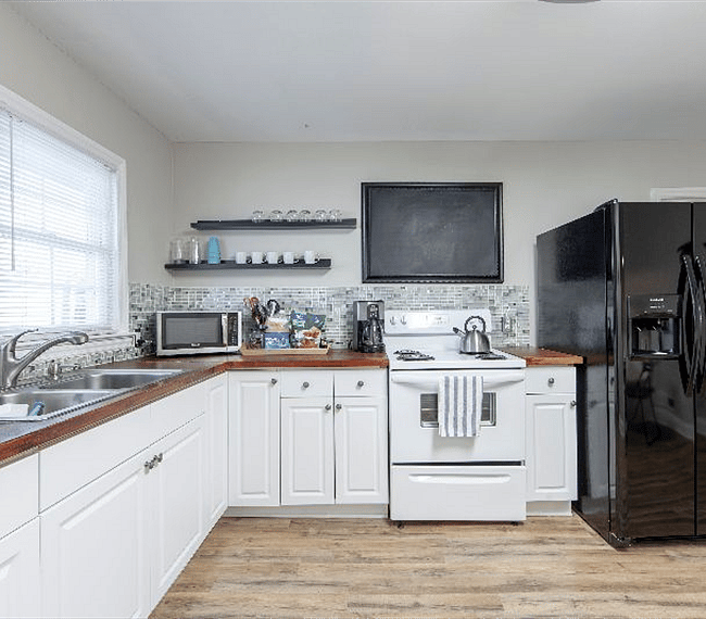 Well appointed kitchen with washer dryer, microwave and everything else you need to enjoy a short or long stay. Door from the kitchen leads out to the shared patio with gas BBQ and outdoor seating area.