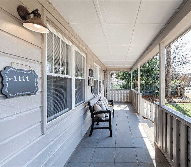 This seat could be yours! Quaint porch overlooking the green lawn and manicured shrubs, and Herrin Ave.