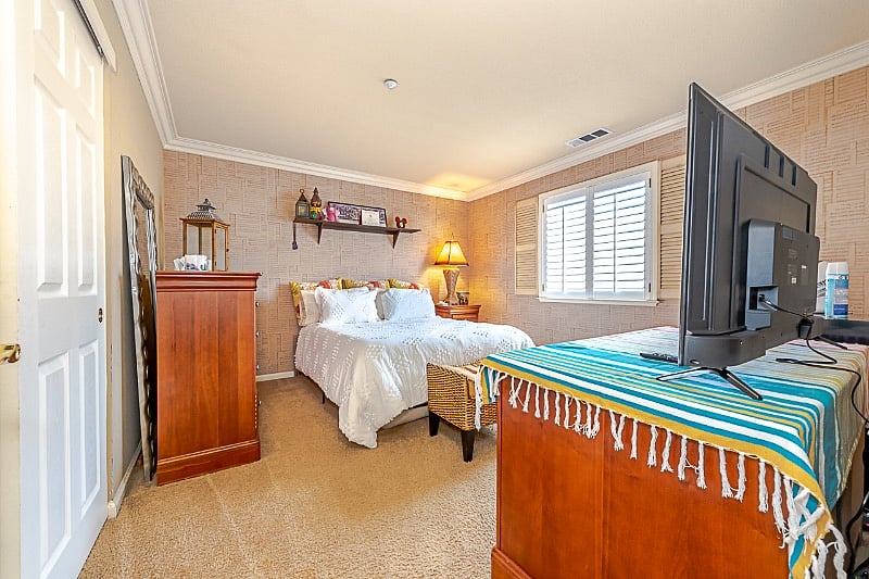 Guest Bedroom A ~ 55inch television, custom wallpaper, desk, dresser, wooden shutters and lots of closet space.
