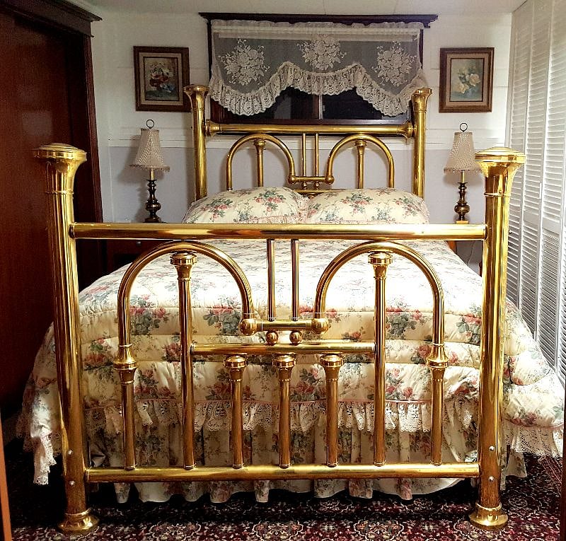 Antique queen-size brass bed, with USB charging outlets on nightstands