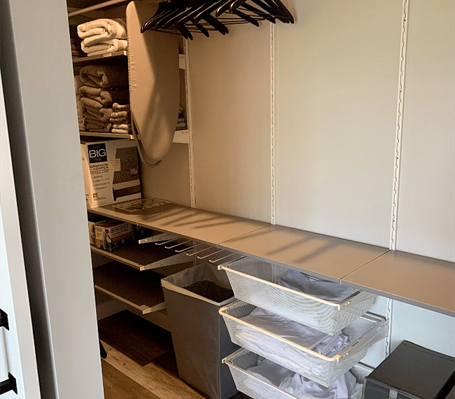 Huge walk-in closet with extra sheets, towels, ironing board, iron, shoe storage.