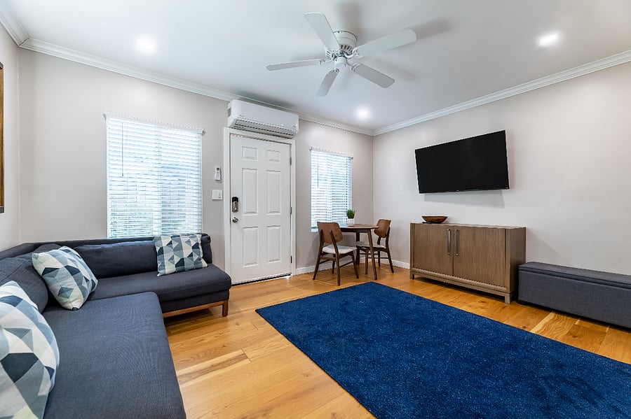 Living room with queen bed folded into wall, dining/working table. 52 inch smart TV with all popular streaming apps installed.