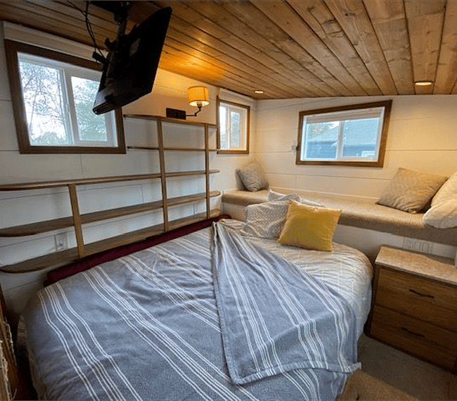 Main bedroom with comfortable Queen bed, and reading loft. A television hangs overhead for cozy movies and favorite TV series. Amazon Fire stick is plugged in for easy access to all your streaming services.