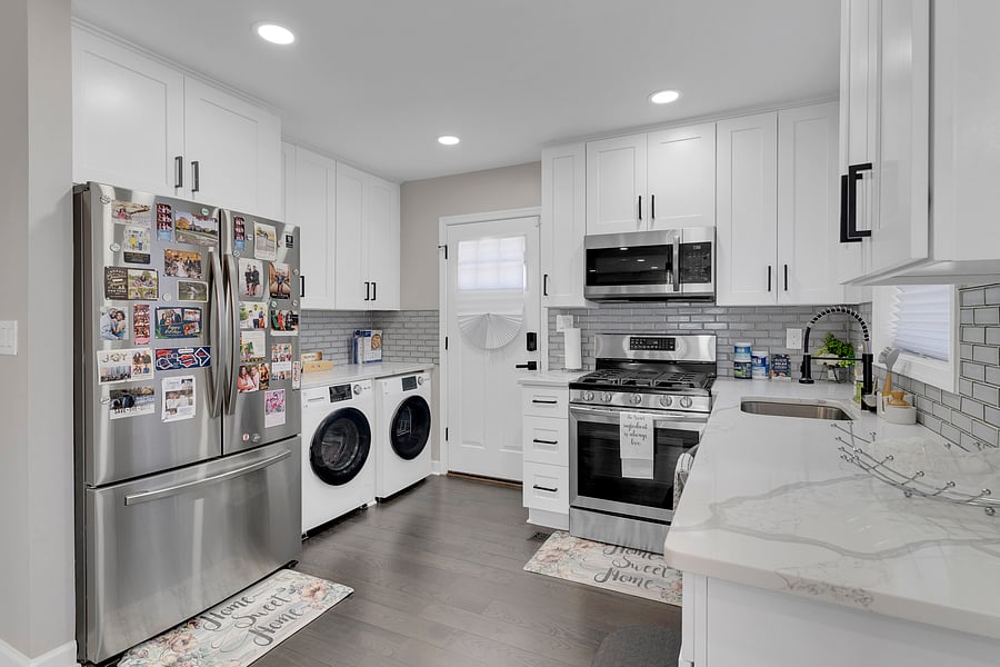 stunning all-white chef's kitchen featuring sleek black accents, premium stainless steel appliances, and elegant quartz countertops.