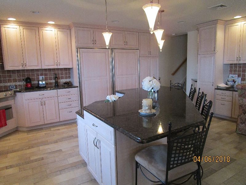 kitchen island seats five, Sub Zero refrigerator and freezer in background 