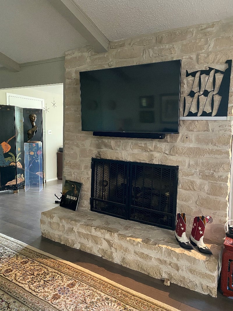 Stone fireplace with smart TV above.