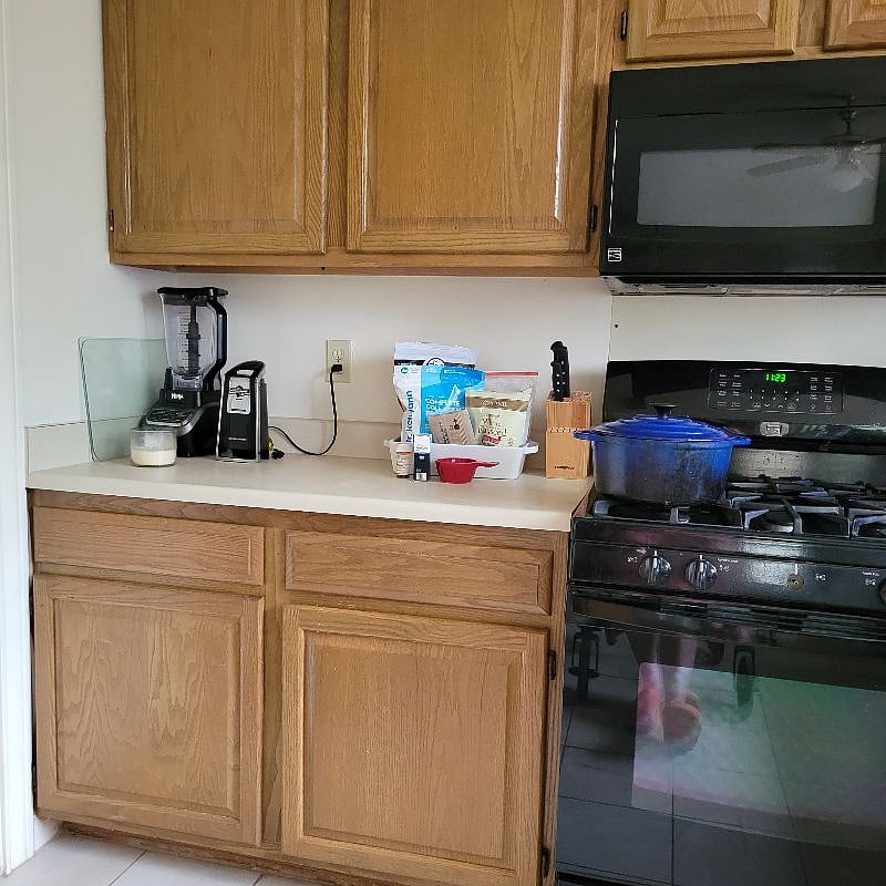 Blender, electric can opener and gas stove with microwave.