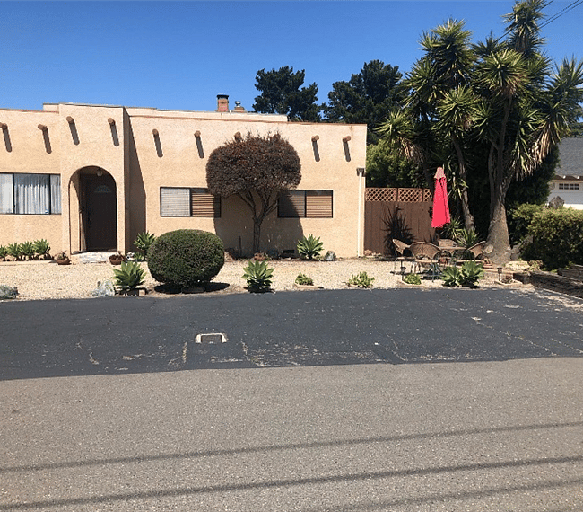 Front yard with personal parking space on paved driveway and private gated entrance