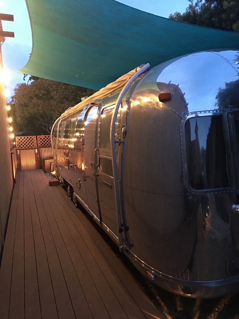The Airstream at night is very well lit with patio string lighting
