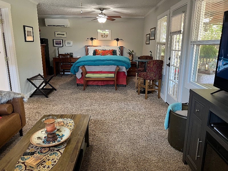 The large bathroom door is opposite the porch door. The queen size bed is elevated to allow 12 inch clearance for underbed storage of luggage and other items. A really great mattress and quality linens and pillows insures excellent comfort as consistently reported by guests. 