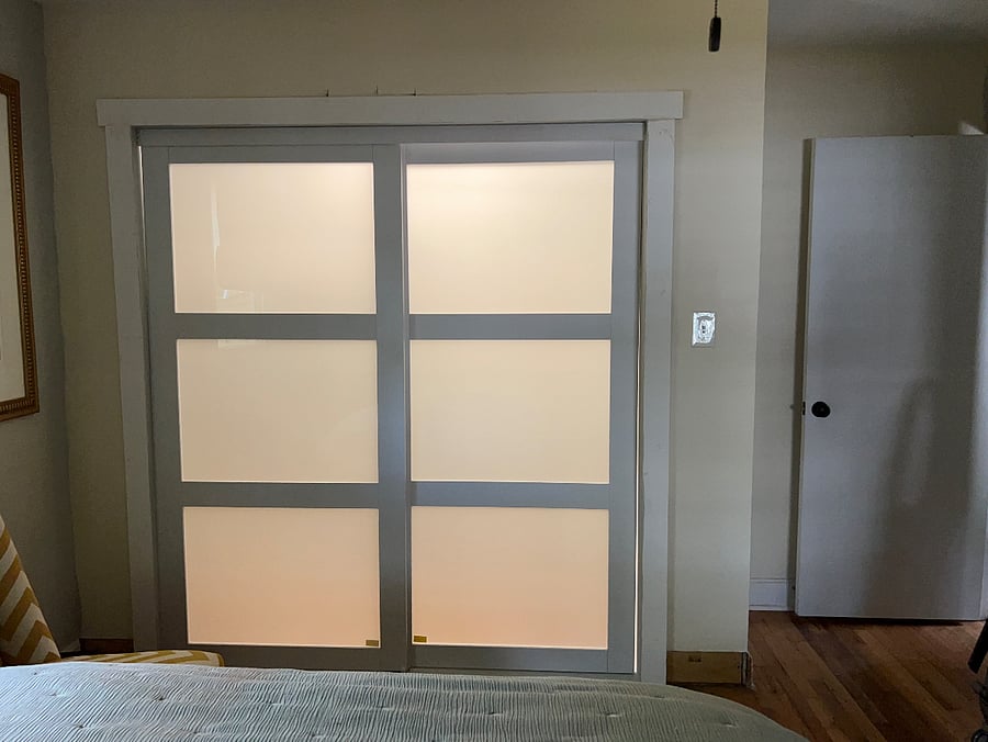 8 ft closet with closet system offers ample storage for 2 people and frosted glass panels allow a soft glow lighting option for the room.