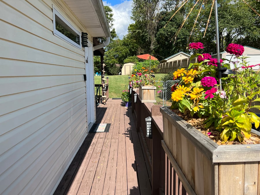 Side deck that connects the home to the large back yard with a covered porch with gas grill and table as well as seating area, a firepit and a small deck mid-yard. The porches and deck are shared spaces.