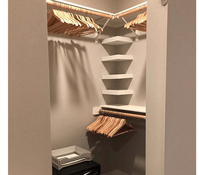 Large walk-in closet with wooden hangers and safe provided.