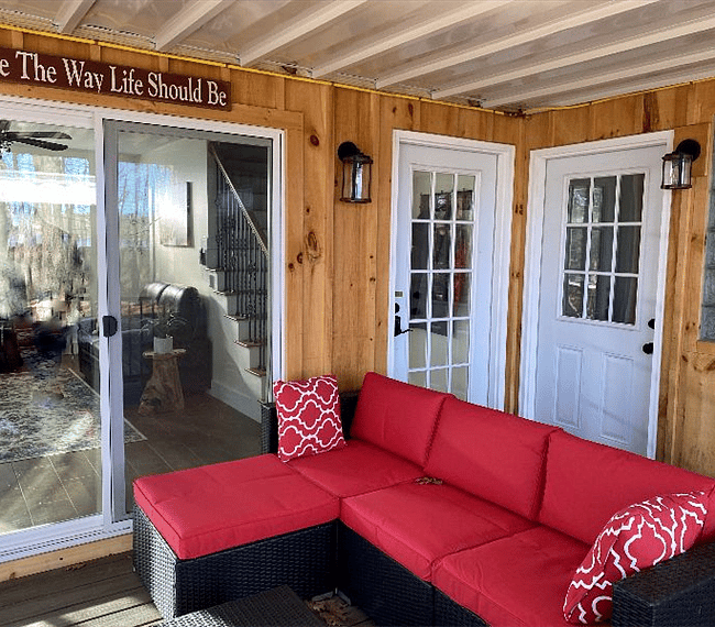 Covered deck with slider into living room, front door & storage room door.