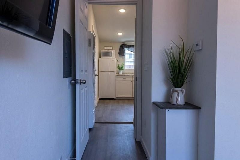 A view from the bedroom through the hallway to the kitchen/living area. 