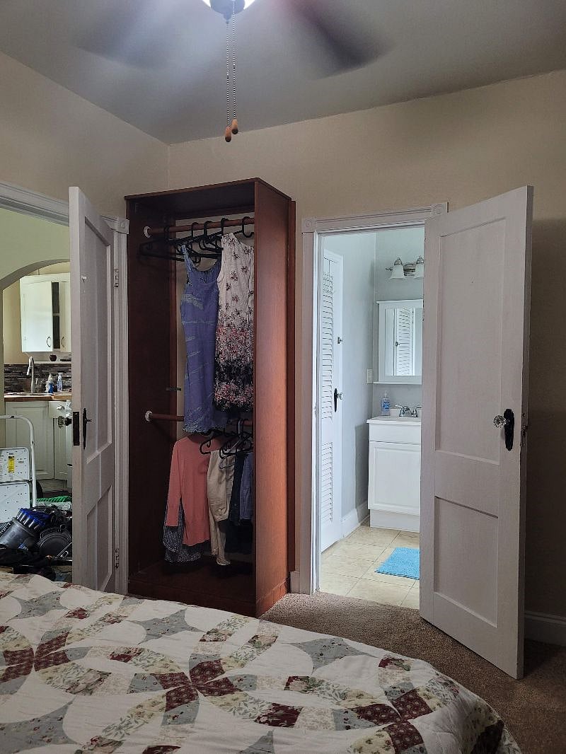 view from bedroom, showing closet, kitchen through the door on the left and bathroom through door on the right.