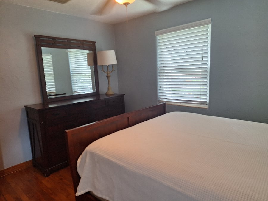 Master bedroom, queen bed and large dresser with mirror and walk-in closet.