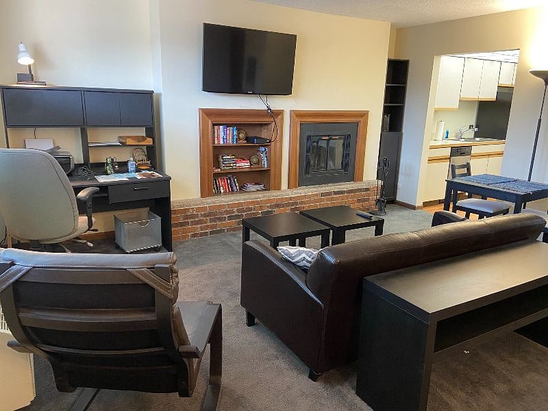 Living room with desk, TV and fireplace