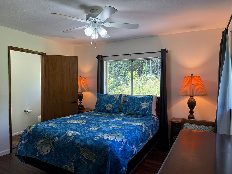 Master Bedroom with new Hawaiian bedspread. Master bedroom with jungle view and plenty of cool ocean breezes!