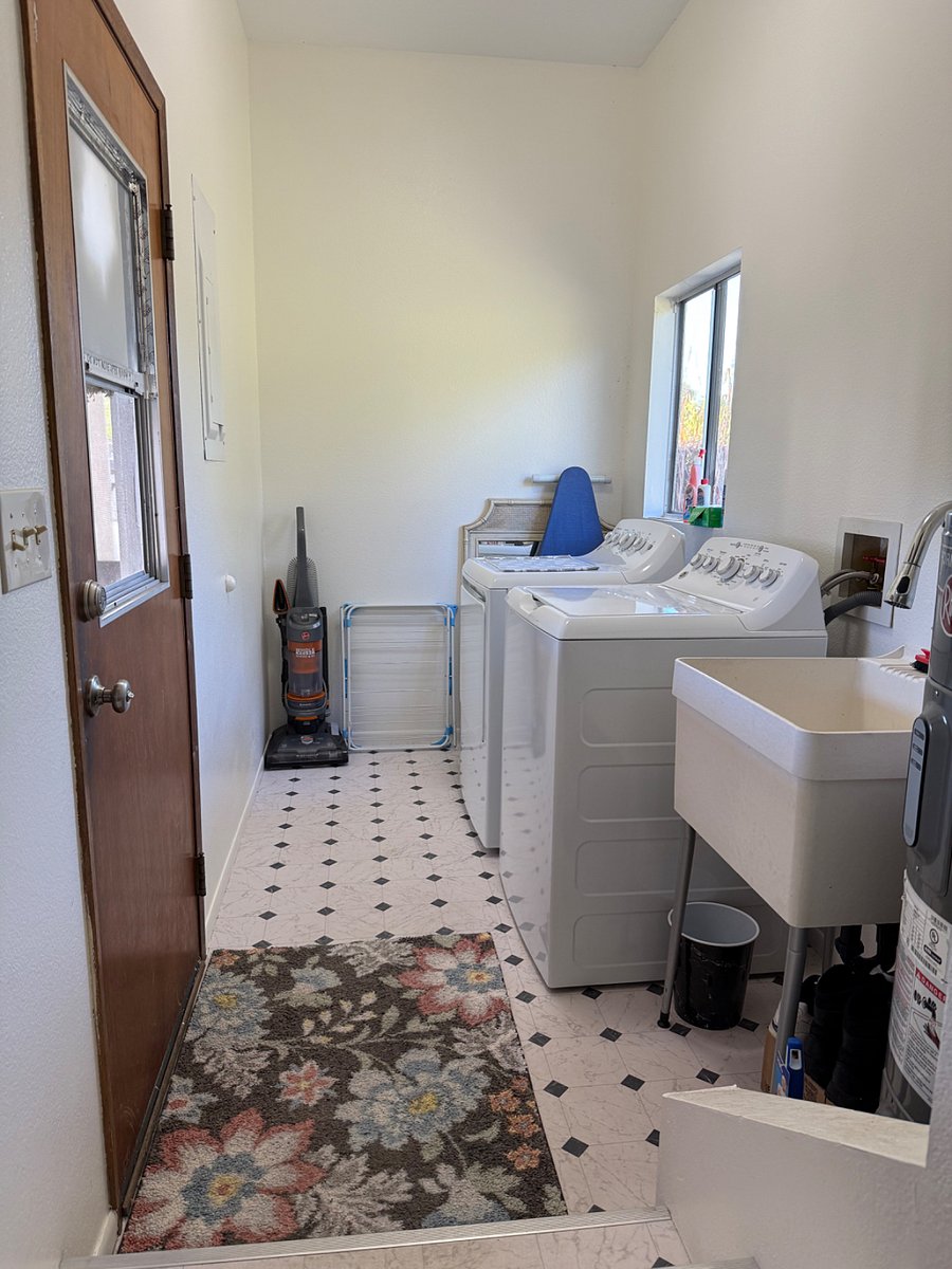 Remodeled laundry room with new large capacity GE washer & dryer, new 50-gallon hot water tank, new utility sink, new vinyl flooring and new paint.